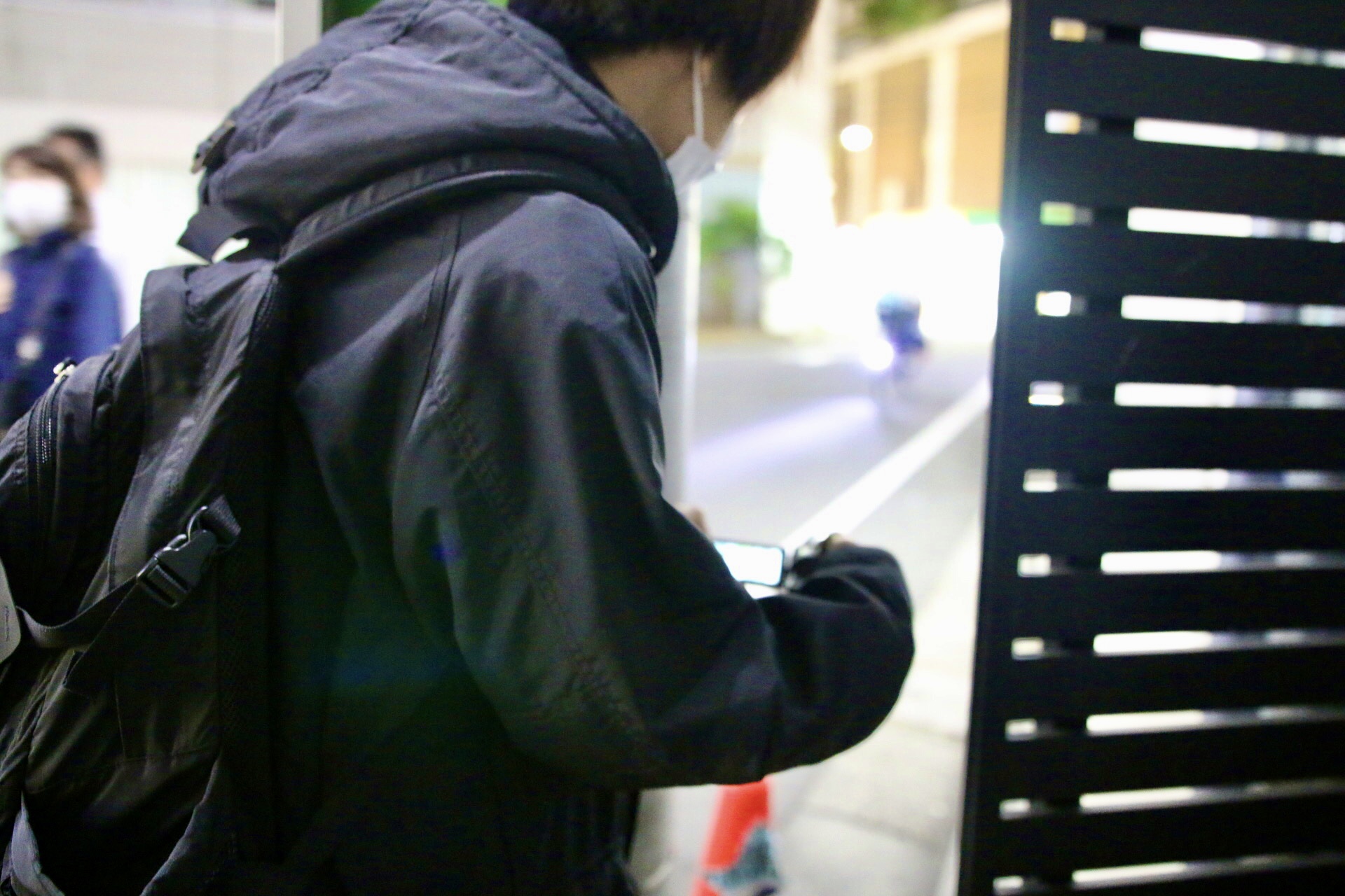 夜の街で対象者の動きを確認する調査員