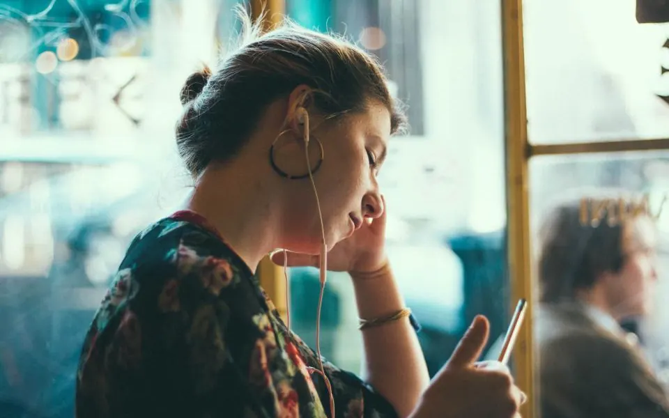 スマートフォンを見つめて考え込む女性