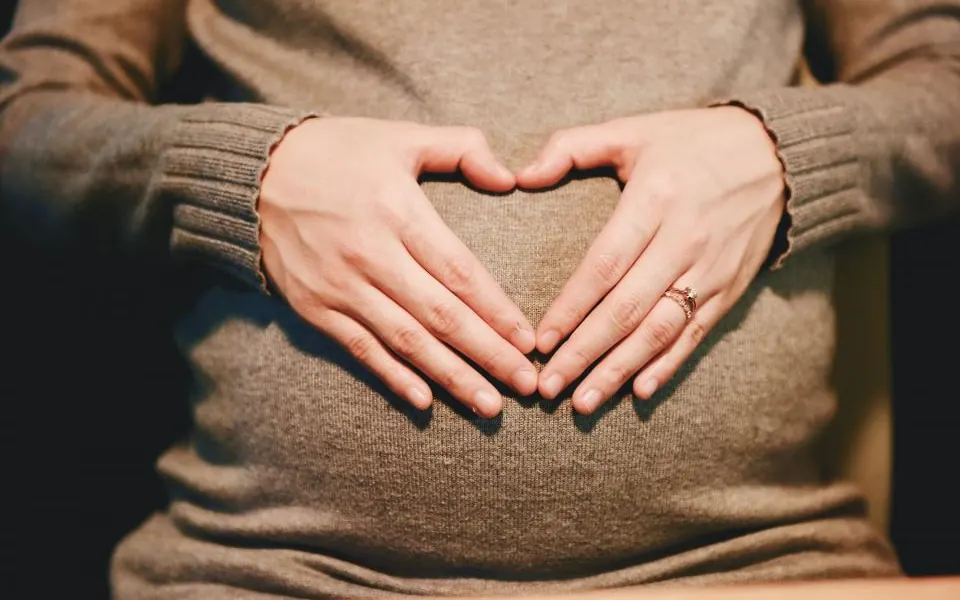 お腹に手を添える妊娠中の女性